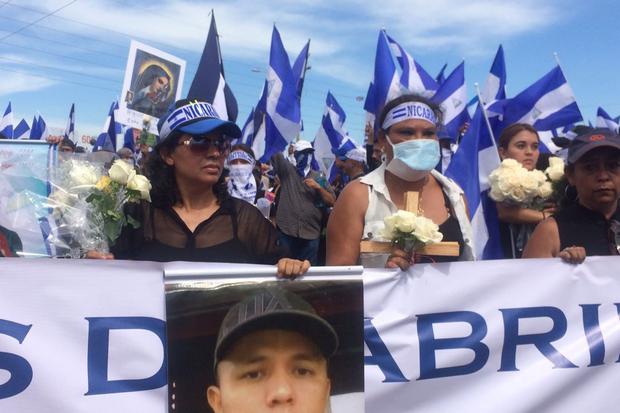 Acompañadas con rosas blancas y fotos de los fallecidos, cientos de personas se congregaron poco a poco para participar en la marcha en honor a las Madres de Abril. Foto: Walkiria Chavarría.