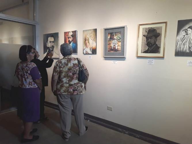 Personas observando la exposición en honor a Rubén Darío.