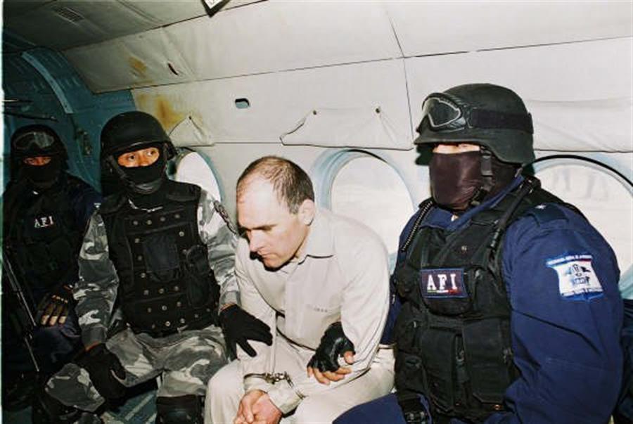 Imagen de archivo de dos policías que escoltan a Osiel Cárdenas (centro), un capo del narcotráfico de México. /EFE