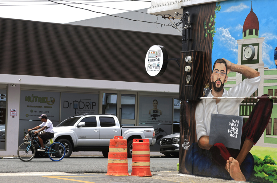 Una persona pasa en bicicleta frente a un mural de Bad Bunny, en Vega Baja (Puerto Rico). /EFE