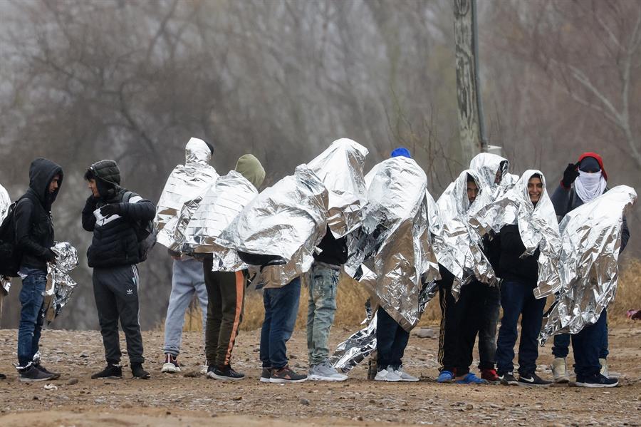 Migrantes se alinean mientras se preparan para ser recogidos por agentes de la Patrulla Fronteriza en Eagle Pass, Texas, EE.UU./ EFE