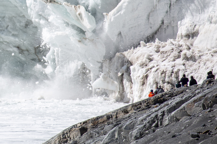Personas observan el desprendimiento de un fragmento de glaciar en la laguna Ventanani este sábado./ EFE