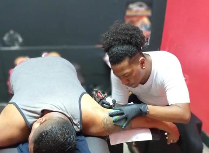 Gerald Román realizando un tatuaje.