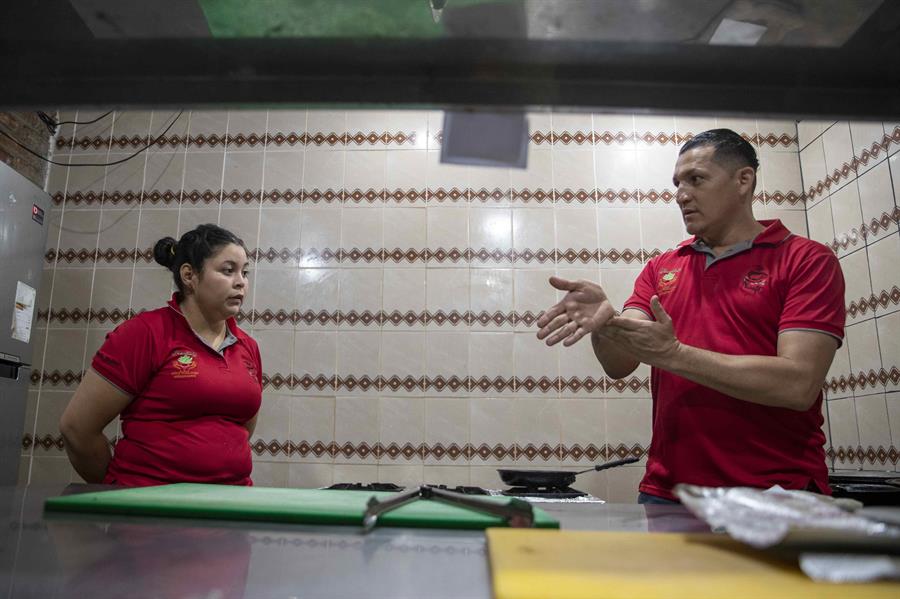 Trabajadores con discapacidad auditiva se comunican por medio de lenguaje de señas en el restaurante Nicafe. / EFE