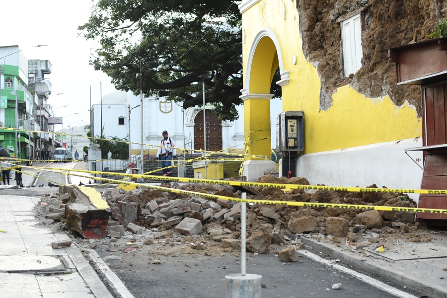 Una persona camina este miércoles cerca de los escombros ocasionados tras los fuertes temblores, en Palín (Guatemala). /EFE
