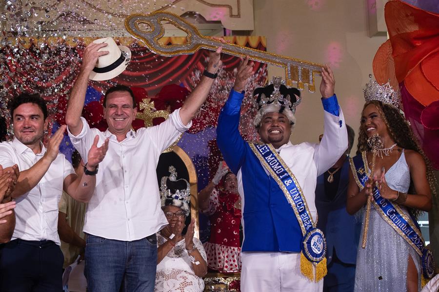 El alcalde de Río de Janeiro, Eduardo Paes (2-i), le entrega las llaves de la ciudad al Rey Momo, Caio César Dutra, y a la reina del carnaval, Gabriella Mendes./ EFE