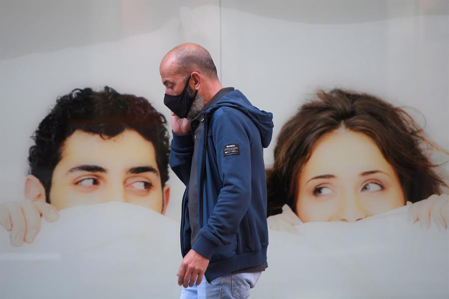 En la imagen de archivo, un hombre camina con su mascarilla. /EFE