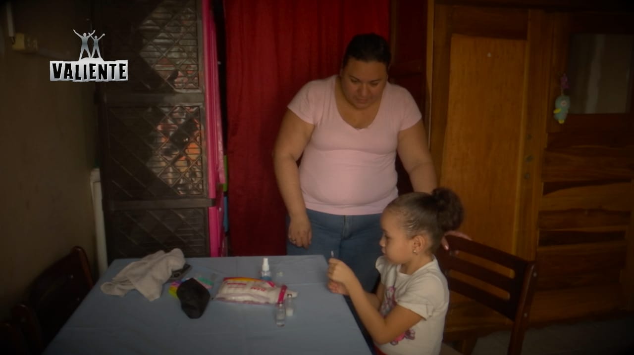 Lilliam enseñando a su hija con diabetes cómo inyectarse insulina 