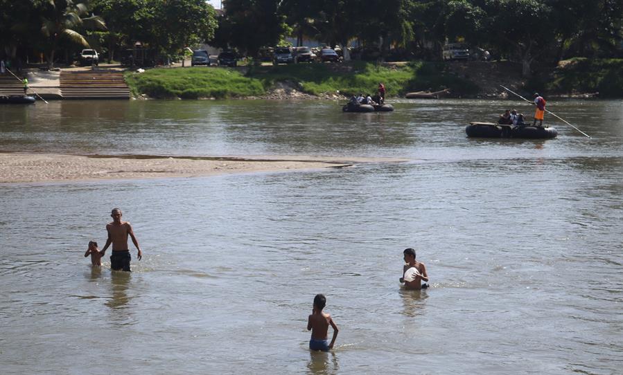 Migrantes se refrescan en el Río Suchiate hoy, en Ciudad Hidalgo, en Chiapas (México). EFE