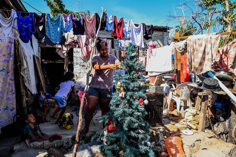 Cristal Ortiz Balderas, habitante de la colonia Cumbres de Figueroa, una de las zonas afectadas por el 'huracán Otis', pone un pino navideño./EFE