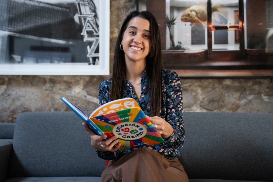 Fotografía de la cocinera uruguaya Ximena Torres posando mientras sostiene su libro./ EFE